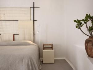 a bedroom with a bed and a potted plant at Boheme Mykonos Town - Small Luxury Hotels of the World in Mikonos