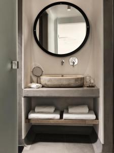 a bathroom with a sink and a mirror at Boheme Mykonos Town - Small Luxury Hotels of the World in Mikonos