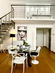 a dining room with a glass table and white chairs at Loft Milano Manifatture in Milan