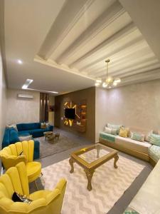 - un salon avec un canapé, des chaises et une table dans l'établissement Impérial appartement 3BR, à Harhoura