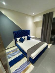 - une chambre avec un lit bleu et des oreillers bleus dans l'établissement Impérial appartement 3BR, à Harhoura