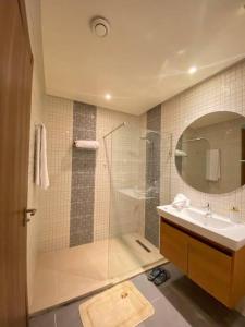 La salle de bains est pourvue d'une douche, d'un lavabo et d'un miroir. dans l'établissement Impérial appartement 3BR, à Harhoura