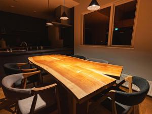 帯広市にあるBuena Vista Tokachi - Vacation STAY 47319vの椅子付きの部屋の木製テーブル