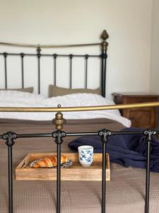een dienblad met brood en een kopje op een bed bij La Maison de Melman in Quettreville-sur-Sienne