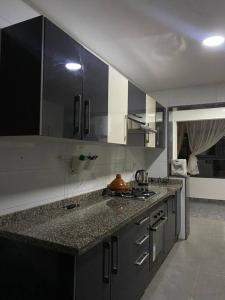 une cuisine avec des placards gris et un comptoir dans l'établissement Impérial appartement 3BR, à Harhoura