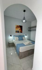 a bedroom with a large bed with a blue blanket at Lava Guesthouse Prive in Karterados