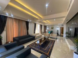 una gran sala de estar con sofás y una mesa. en Khawarnaq Palace Hotel en Nayaf
