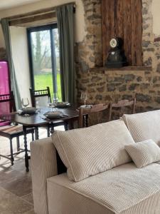 een woonkamer met een bank en een eettafel bij La Maison de Melman in Quettreville-sur-Sienne