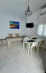 a living room with a table and chairs and a couch at Lava Guesthouse Prive in Karterados