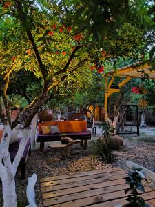 a garden with a table and a bench under a tree at Litost Cafe Bungalow in Adrasan