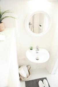 Baño blanco con lavabo y espejo en Whitelist Studios in Mykonos Town en Mykonos ciudad