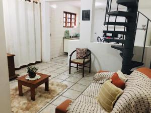 een woonkamer met een bank en een wenteltrap bij Apto Duplex confortável a apenas 2 km do Capivari in Campos do Jordão