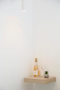 Un estante con dos botellas y una planta. en Whitelist Studios in Mykonos Town en Mykonos ciudad