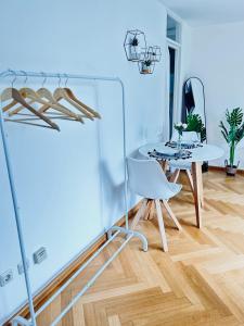 a dining room with a white table and a white chair at Stilvolles Apartment - Unteraching in Unterhaching