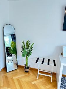 a mirror in a room with a table and a plant at Stilvolles Apartment - Unteraching in Unterhaching