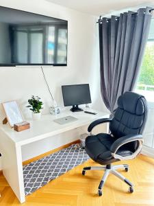 a desk with a computer and a chair in a room at Stilvolles Apartment - Unteraching in Unterhaching