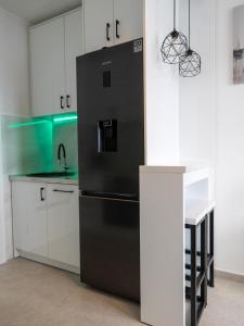 Bileća的住宿－Aurora studio - Bileca，厨房配有黑冰箱,厨房配有白色橱柜