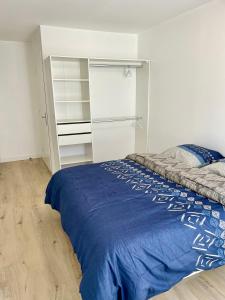 a bedroom with a bed with a blue blanket at Chambre Confort - Douche Privative - Jardin - Parking Gratuit in Argenteuil