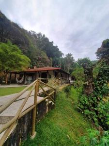 ein Haus mit einem Holzzaun davor in der Unterkunft Casa Sítio de sol in Penedo