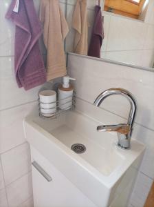 uma casa de banho com lavatório, espelho e toalhas em Vikendica Raj em Bihać