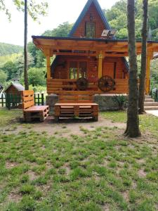 uma cabana de madeira com um banco à frente em Vikendica Raj em Bihać
