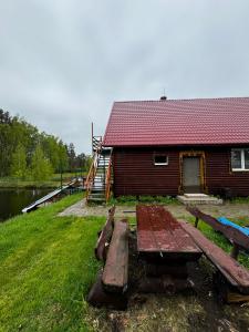 a picnic table sitting in front of a cabin at Vasaras māja Rāzna - Pirts 