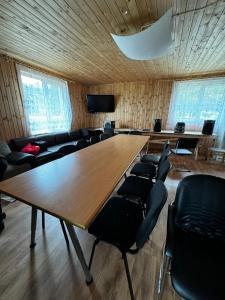 una sala de conferencias con una gran mesa de madera y sillas en Vasaras māja Rāzna - Pirts, 