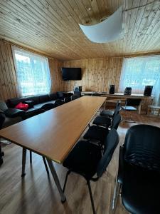 a conference room with a large wooden table and chairs at Viesu māja Rāzna - Pirts in Ragi