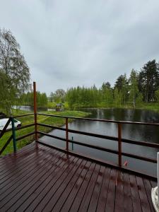 a wooden deck with a view of a lake at Viesu māja Rāzna - Pirts in Ragi +15 photos