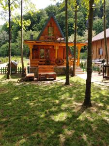 uma cabana de madeira no meio de um parque com árvores em Vikendica Raj em Bihać