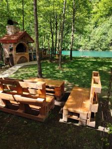 uma mesa de piquenique e bancos num parque em Vikendica Raj em Bihać