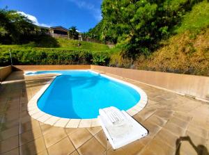 una piscina con un banco al lado en TAHITI - Amoe Condo, en Mahina