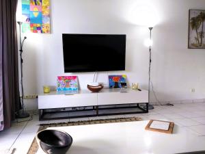 uma sala de estar com televisão numa parede branca em TAHITI - Amoe Condo em Mahina