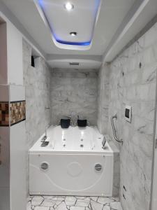 baño con bañera blanca y paredes de piedra. en Hotel Los Inkas en Huaraz