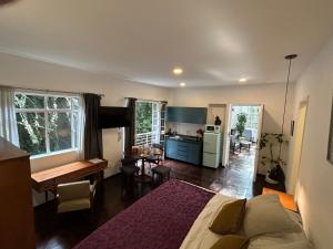 a bedroom with a large bed and a kitchen at Roma Deco Suites in Mexico City