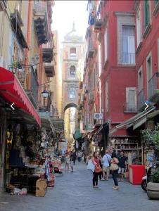 a group of people walking through a street with buildings at The Cave in Naples