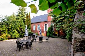 a patio with a table and chairs and a building at Hotel Kamil in Kwidzyn