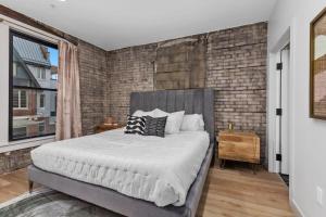a bedroom with a large bed and a brick wall at Grand Rapids Whole Building Rental in Grand Rapids