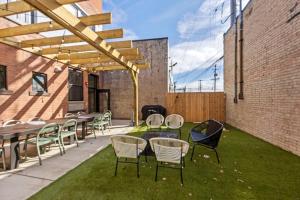 a patio with tables and chairs on the grass at Grand Rapids Whole Building Rental in Grand Rapids