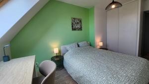 a bedroom with a bed and a green wall at Le clos des Boucaniers in Berck-sur-Mer