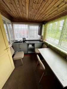 KaunataにあるVasaras mājiņa Nr.2の小さなキッチン(椅子2脚、テーブル1台付)、窓2つが備わります。