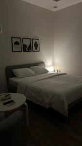 een slaapkamer met een bed en een tafel en foto's aan de muur bij غرفة و حوش بمدخل خاص و دخول ذكي in Riyad