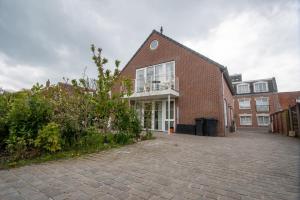 a brick building with a balcony on top of it at Appartementen Zee Domburg in Domburg