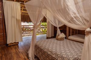 a bedroom with a bed with a canopy at Paraíso Natural Ecohotel in San Bernardo del Viento