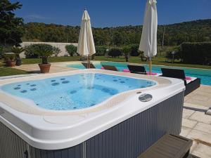 un bain à remous sur une terrasse à côté d'une piscine dans l'établissement Villa in Campagna con Piscina Privata, à Uri