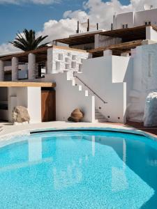 a villa with a swimming pool in front of a house at Boheme Mykonos Town - Small Luxury Hotels of the World in Mikonos