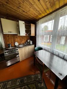 uma cozinha com uma mesa e uma grande janela em Vasaras mājiņa Nr.3 em Kaunata