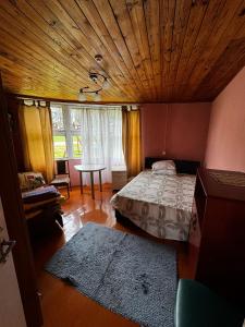 um quarto com uma cama e um tecto de madeira em Vasaras mājiņa Nr.3 em Kaunata