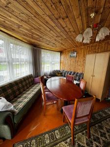 uma sala de estar com um sofá e uma mesa em Vasaras mājiņa Nr.3 em Kaunata