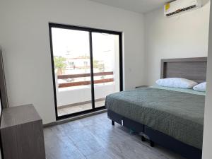 - une chambre avec un lit et une grande fenêtre dans l'établissement Casa Villa Teques, à Tequesquitengo